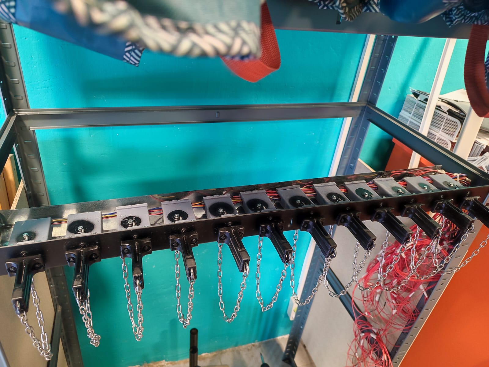 Work-in-progress metal rack frame with electric locks mounted and 3D printed handheld components attached